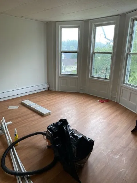 Hillside Ave #3S room with hardwood floors and a bay of tall windows