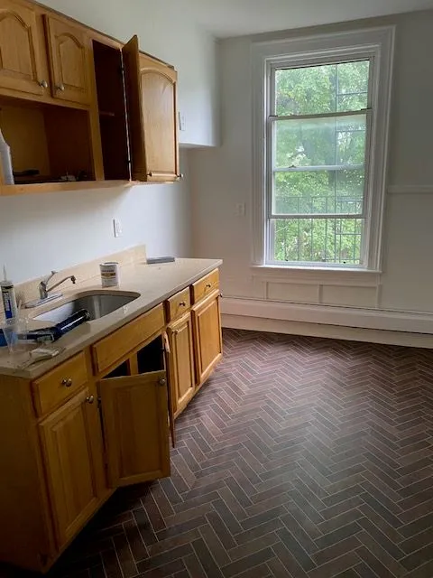 Hillside Ave #3S kitchen with wood cabinets, a sink, and herringbone floor tile